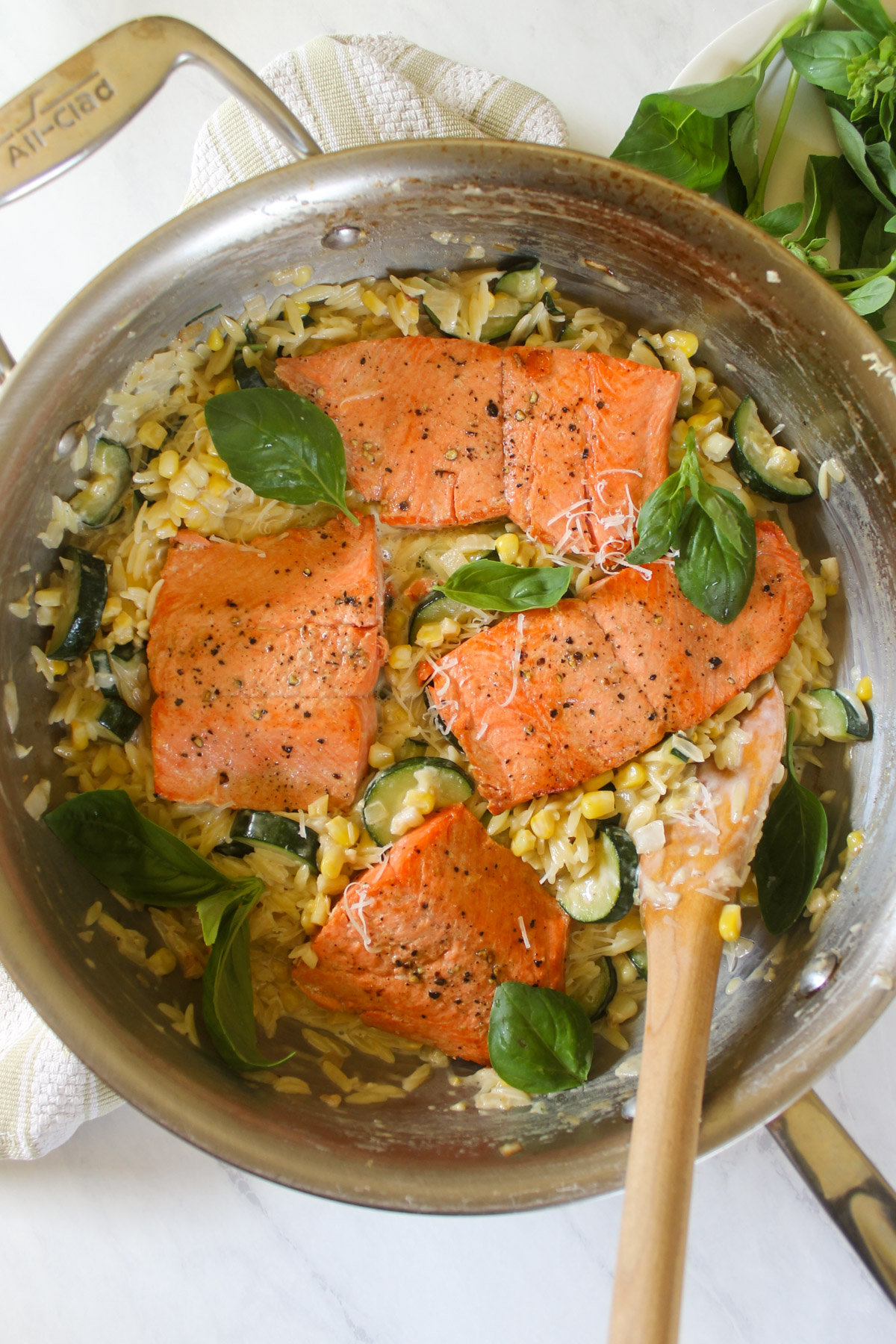 Nestling the cooked salmon onto a bed of creamy orzo with zucchini and corn.