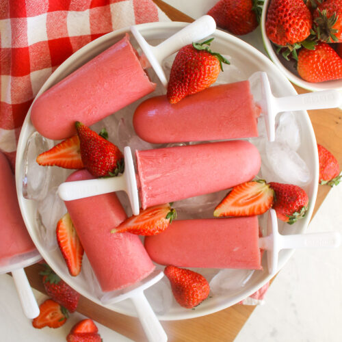 Strawberry Yogurt Popsicles on a white round plate with a red and white checkered napkin.