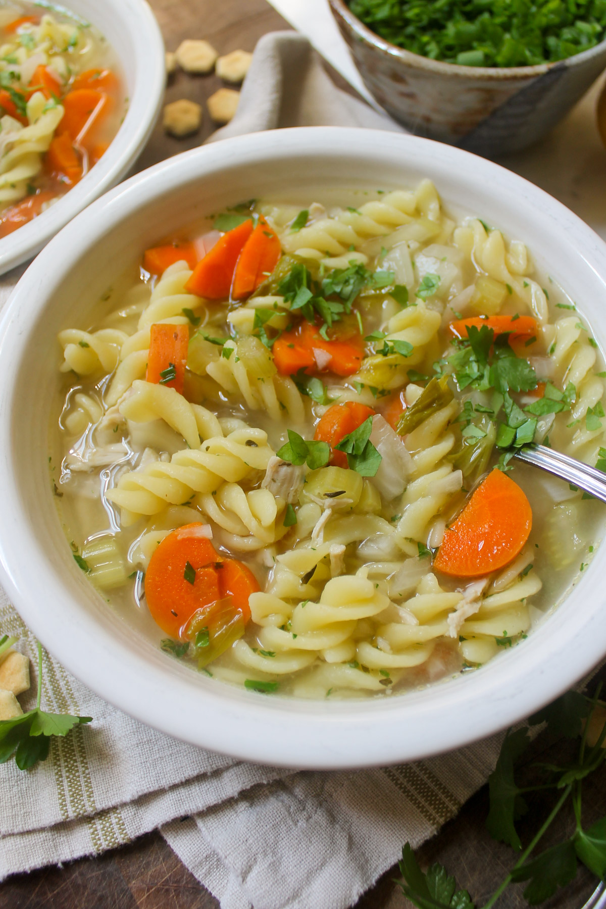 A white bowl of chicken noodle soup.