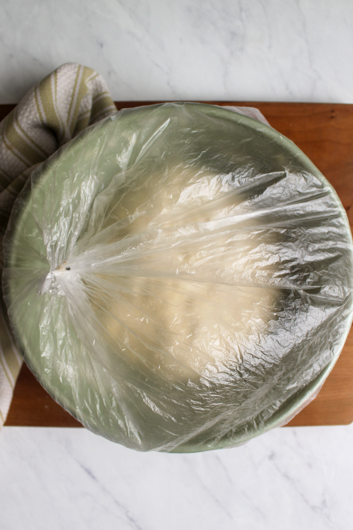 A plastic bag over a bowl of bread dough ready to sit out overnight.