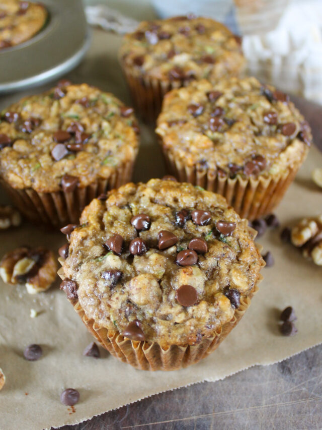 Zucchini muffins on parchment paper with chocolate chips.