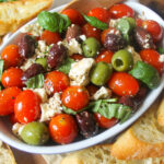 Cherry tomatoes mixed with black and green olives, feta cheese and basil with dressing.