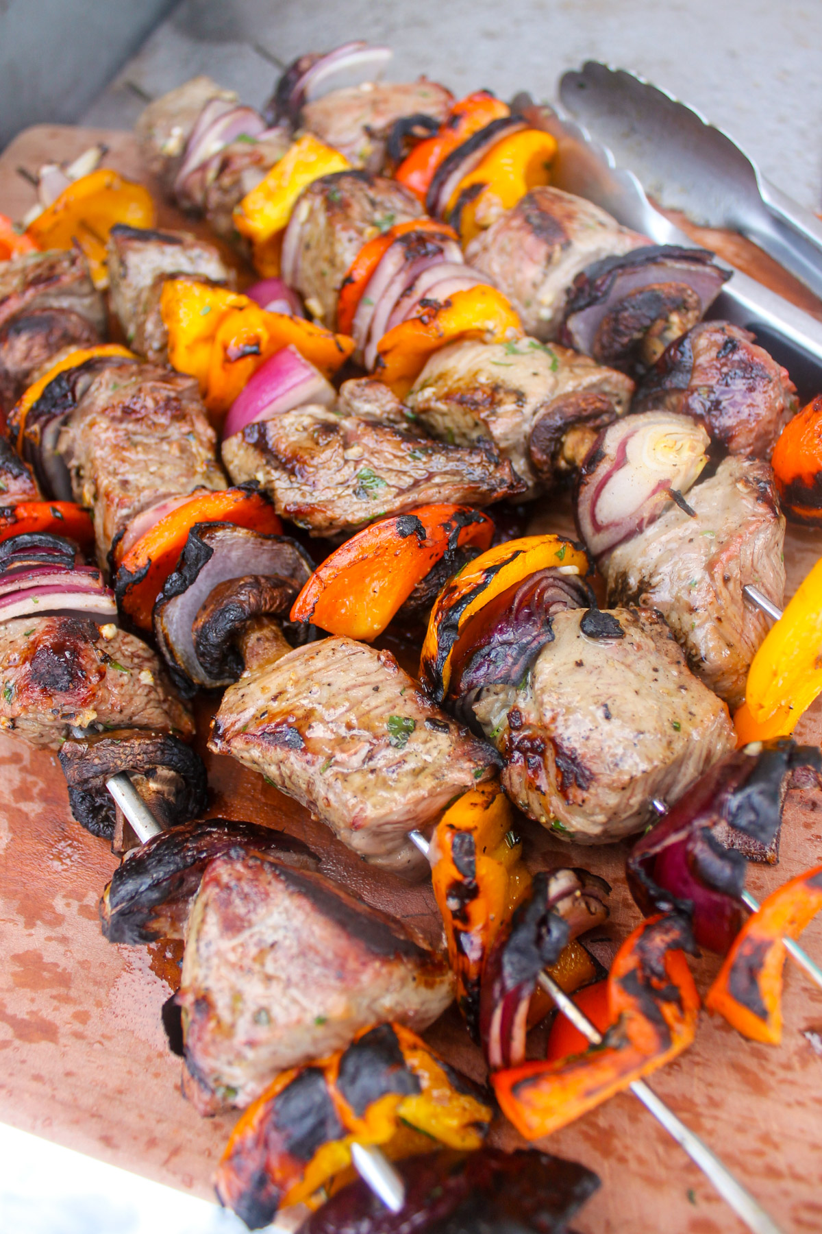Grilled steak and pepper kabobs on a cutting board.