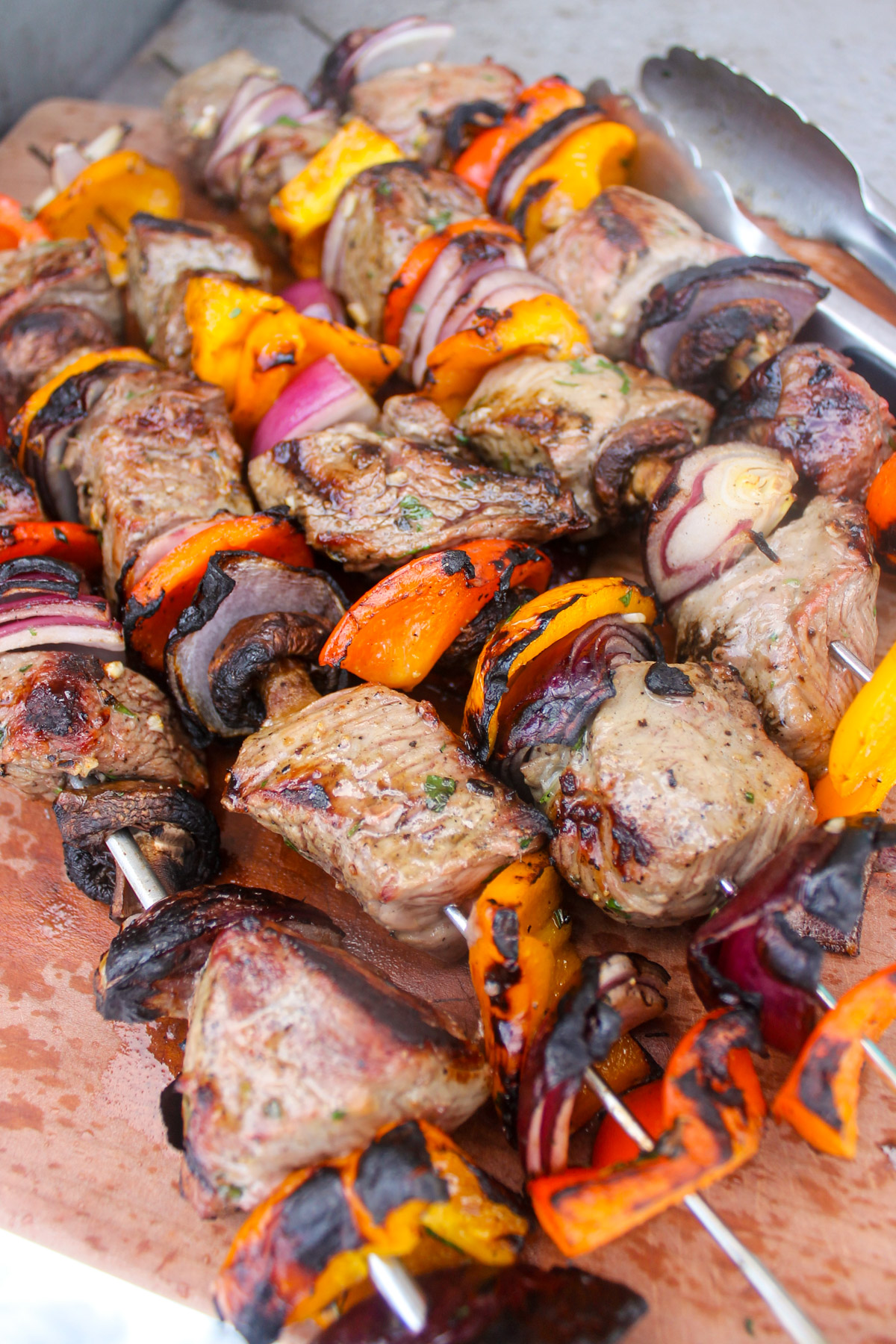 Grilled steak and pepper kabobs on a cutting board.