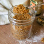 A spoonful of homemade brown sugar from a jar.
