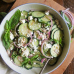 A bowl of Cucumber Feta Salad with red onion slices.