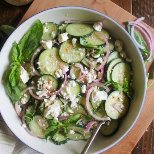A bowl of Cucumber Feta Salad with red onion slices.
