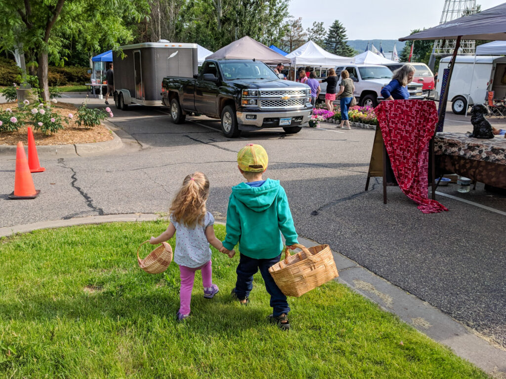Kids carrying baskets to a farmer's market.