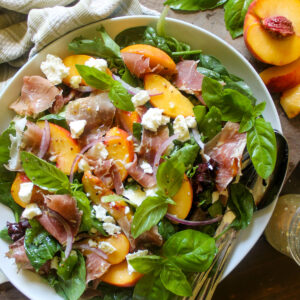 Salad with fresh peach slices, prosciutto and basil.