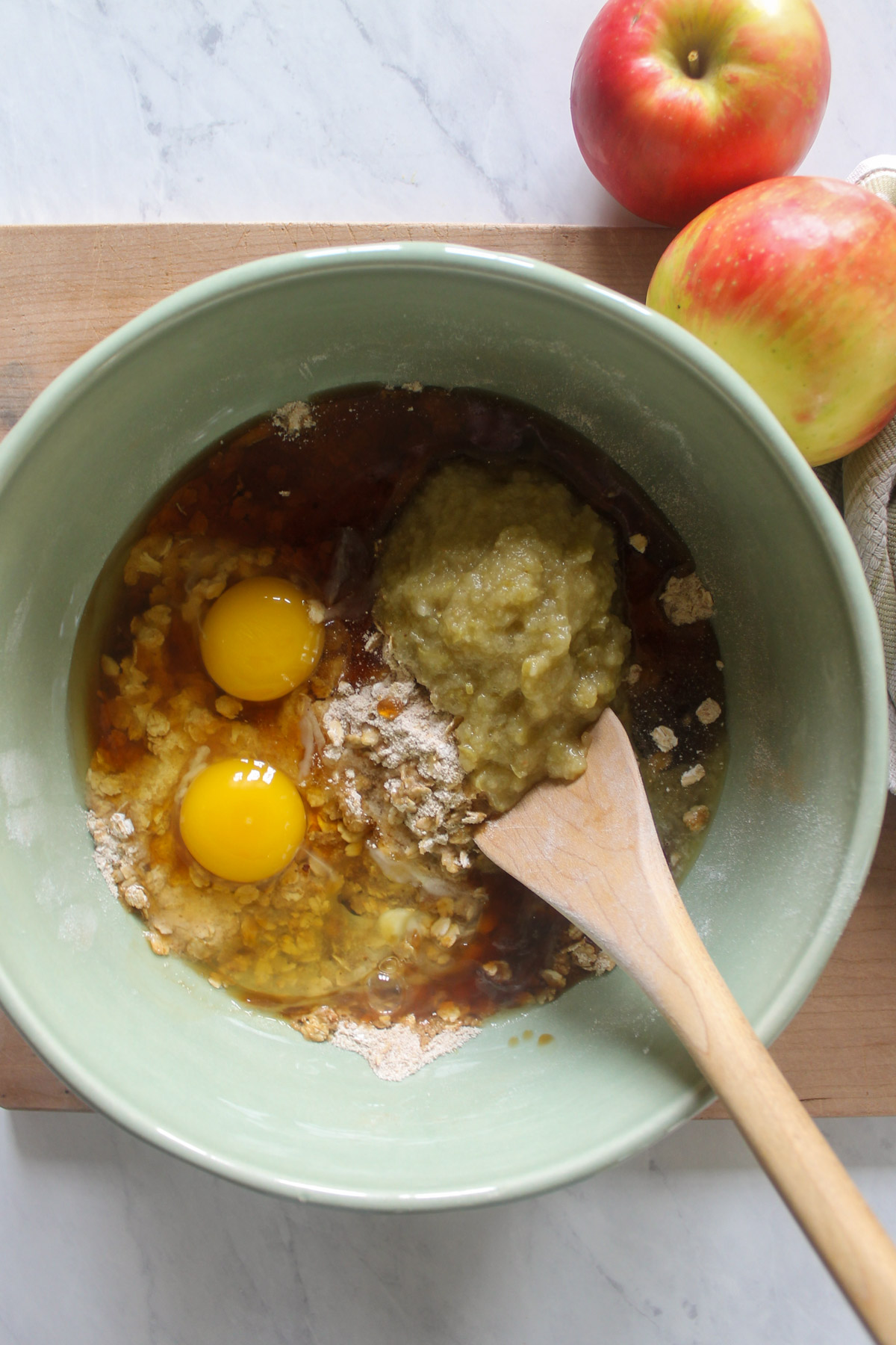 A bowl of unmixed batter with a wooden spoon.