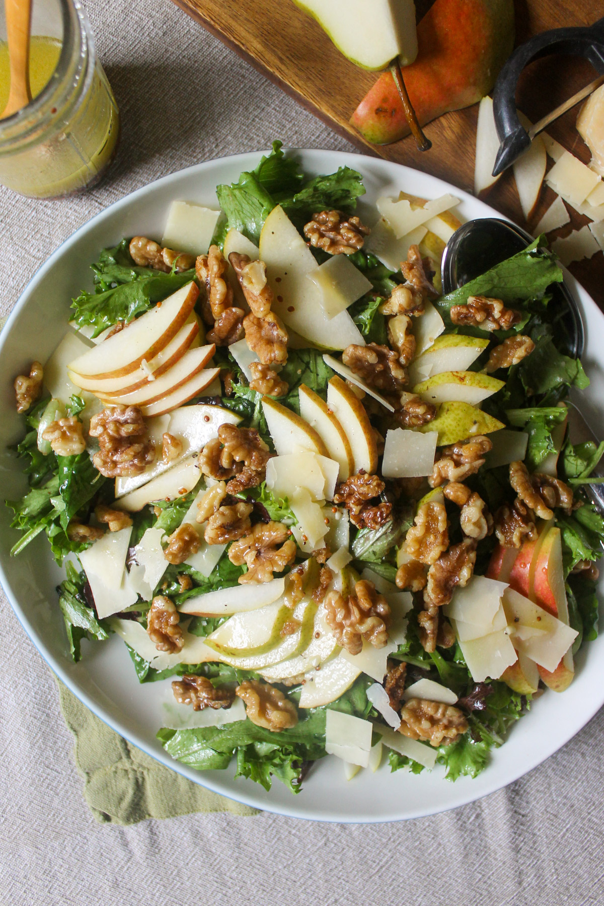 Pear and Parmesan Salad on a platter with walnuts and vinaigrette.