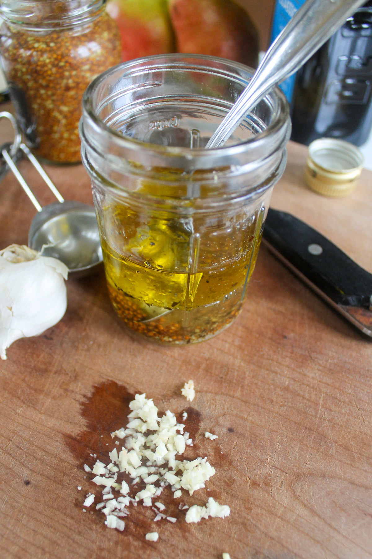 Making vinaigrette salad dressing in a jar with fresh minced garlic.