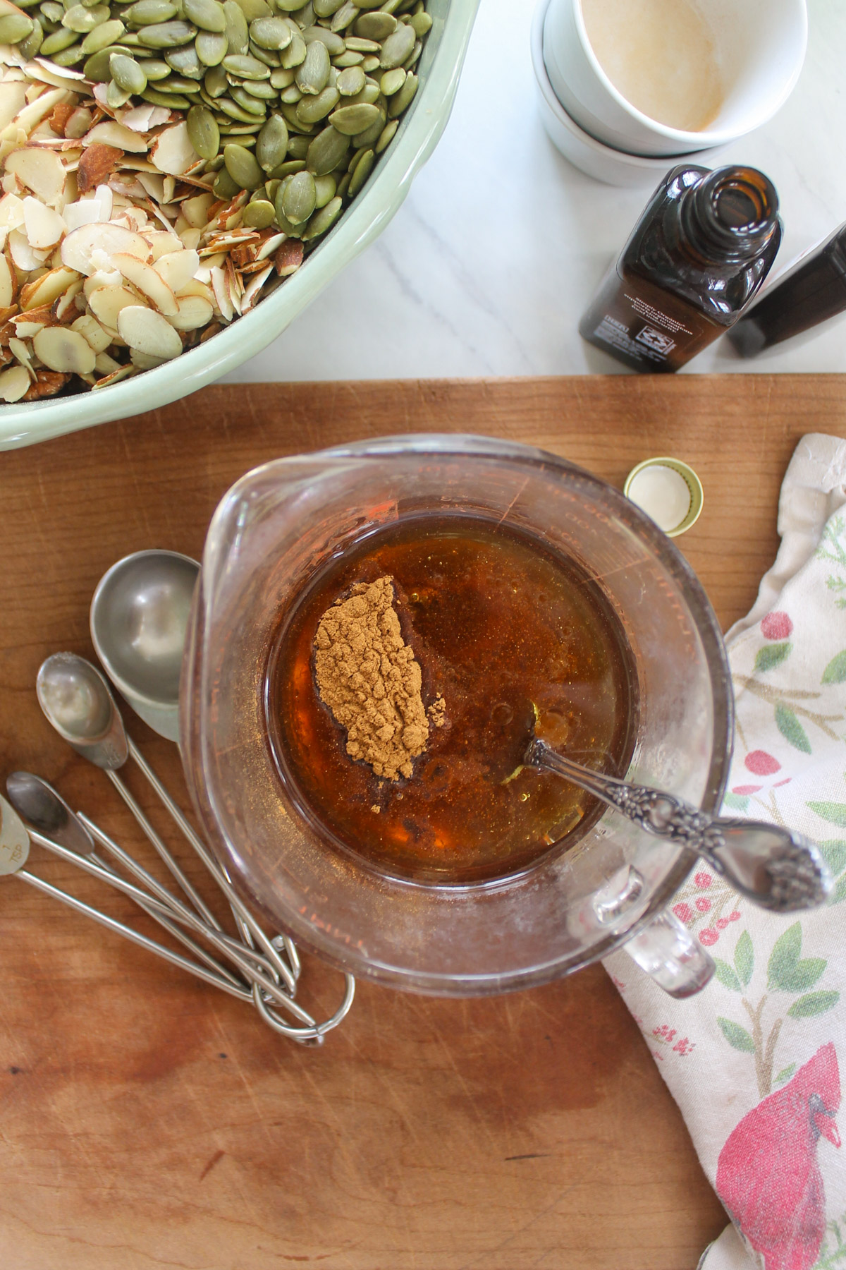 A glass measuring cup of oil, honey and seasoning for granola.