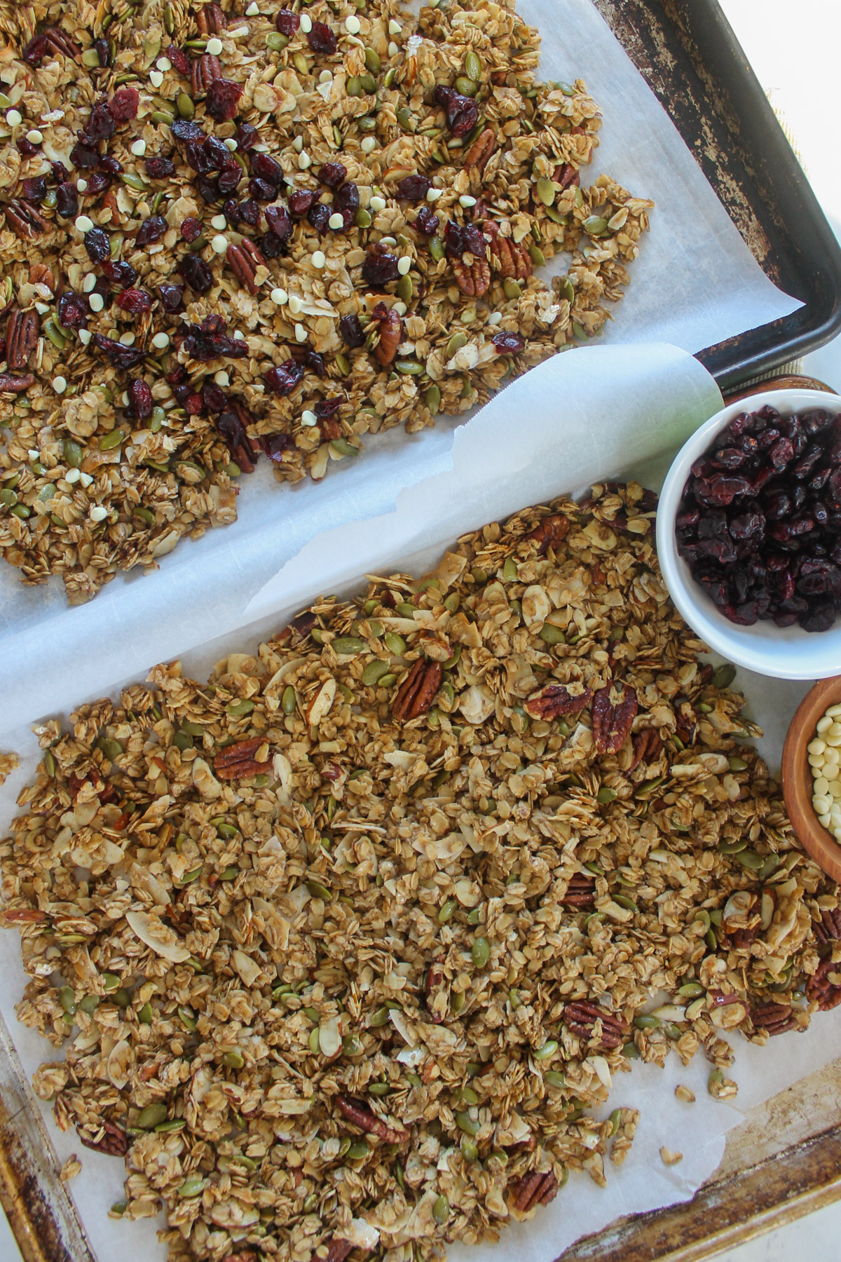 Two sheet pans of baked granola on sheet pans.