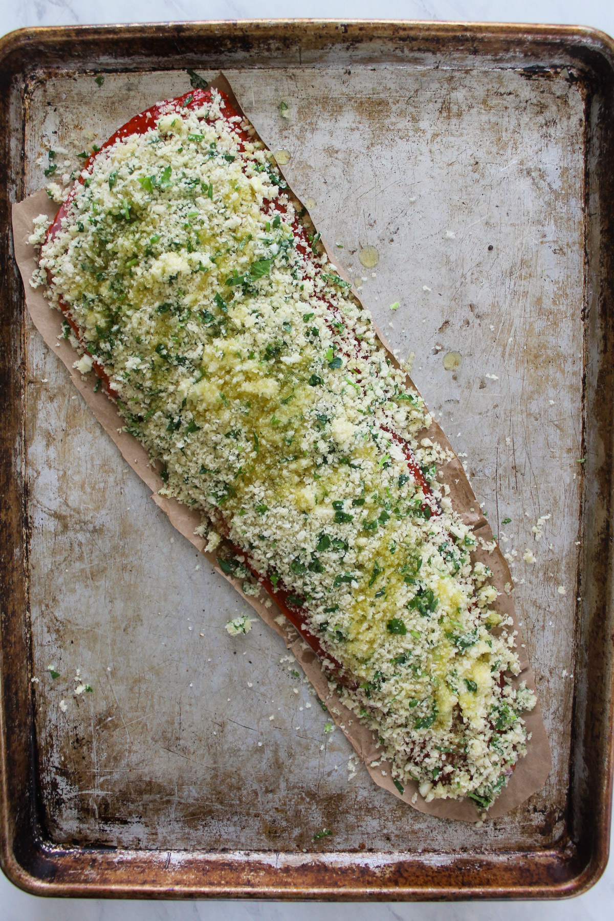 A raw salmon filet with panko garlic bread crumbs coating the top.