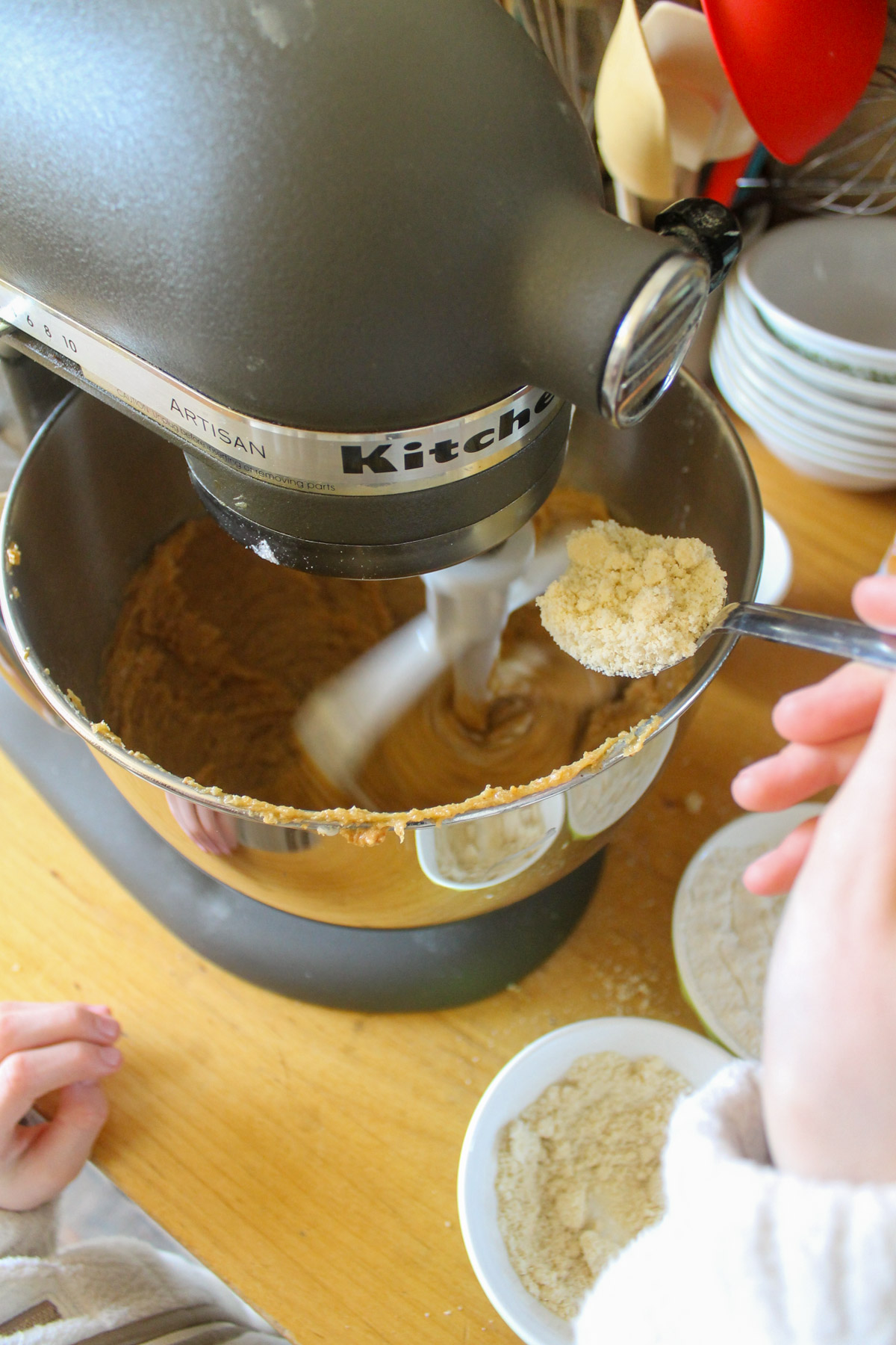 Adding flour to cookie batter in a mixer.