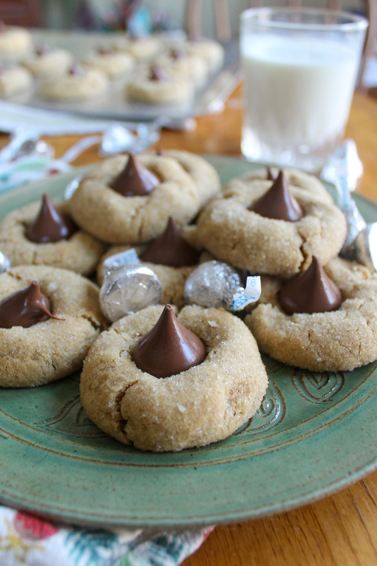 Peanut Butter Blossom Cookies on a plate with a glass of milk.