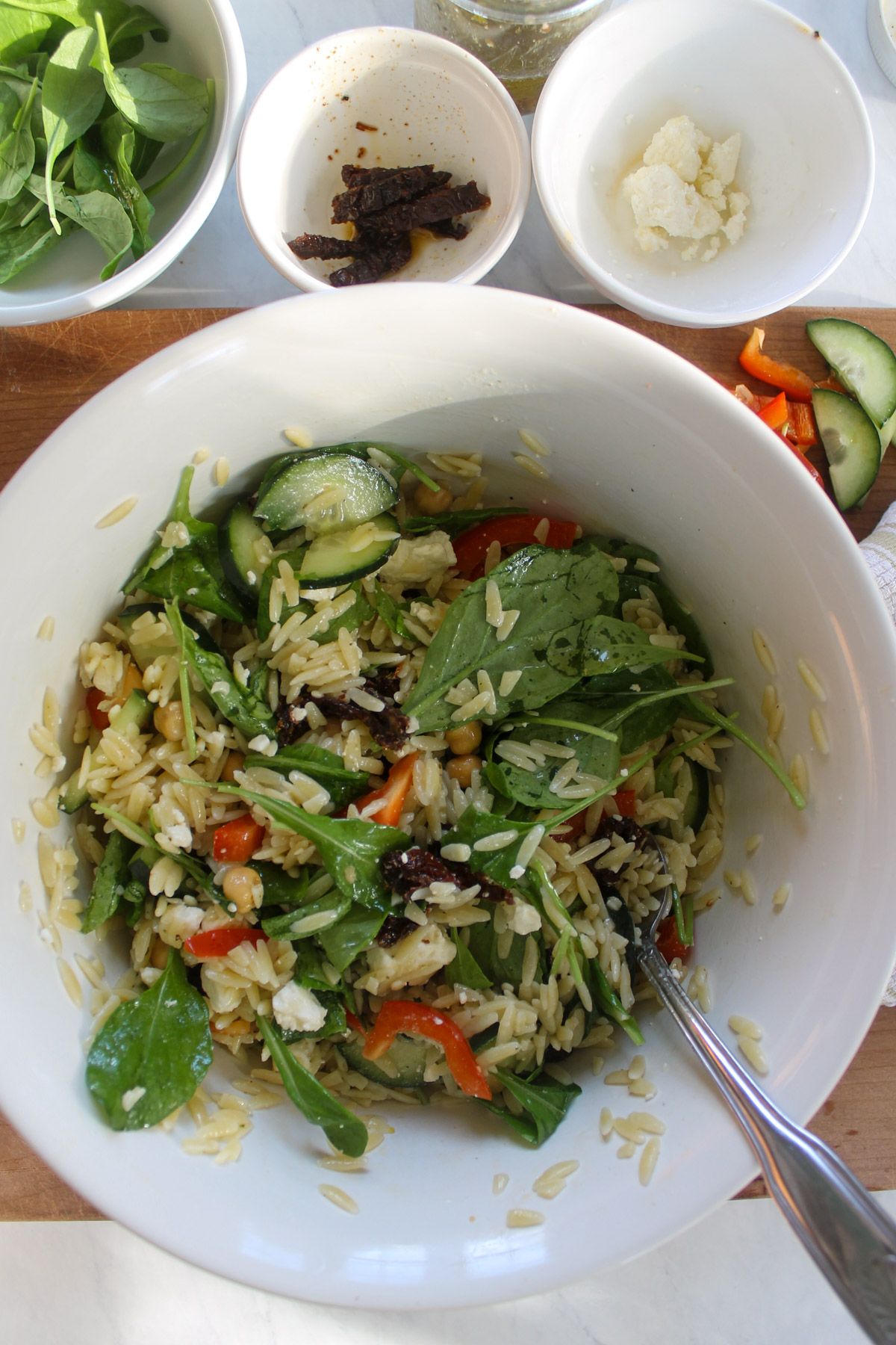 Orzo pasta salad in a mixing bowl.