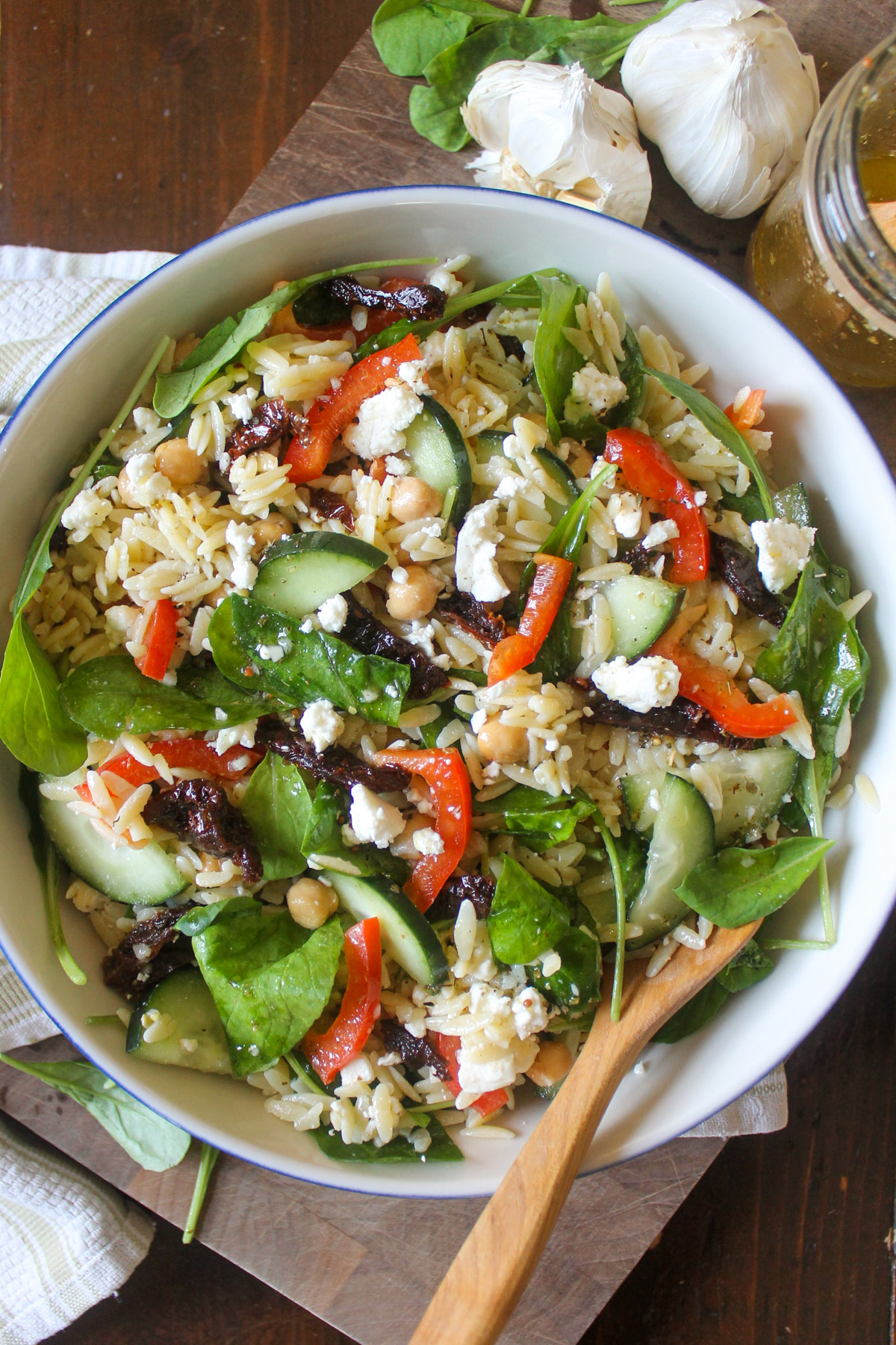 A bowl of Arugula Orzo Pasta Salad with Sun-Dried-Tomatoes.