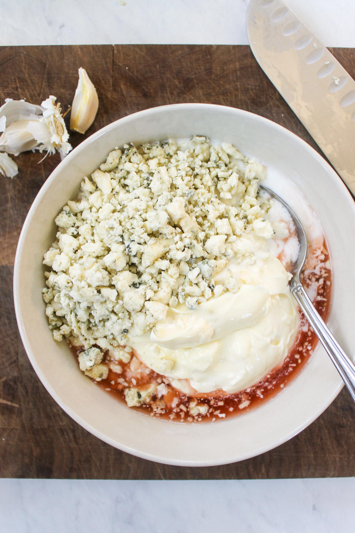 Blue cheese crumbles, red wine vinegar, mayo and buttermilk in a bowl.