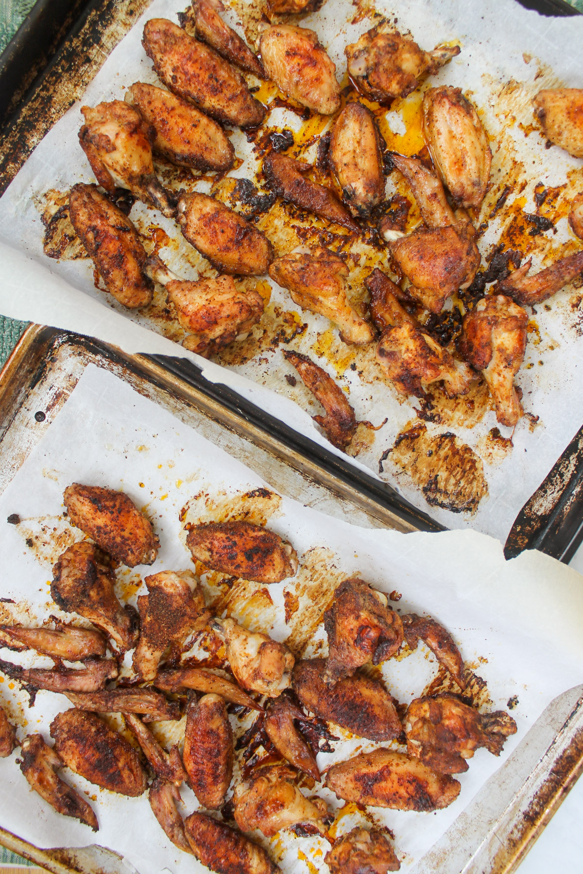 Two pans of oven baked chicken wings with dry rub.