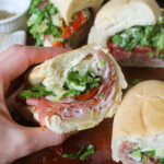 A hoagie bun grinder sandwich with Italian deli meats and Provolone cheese.