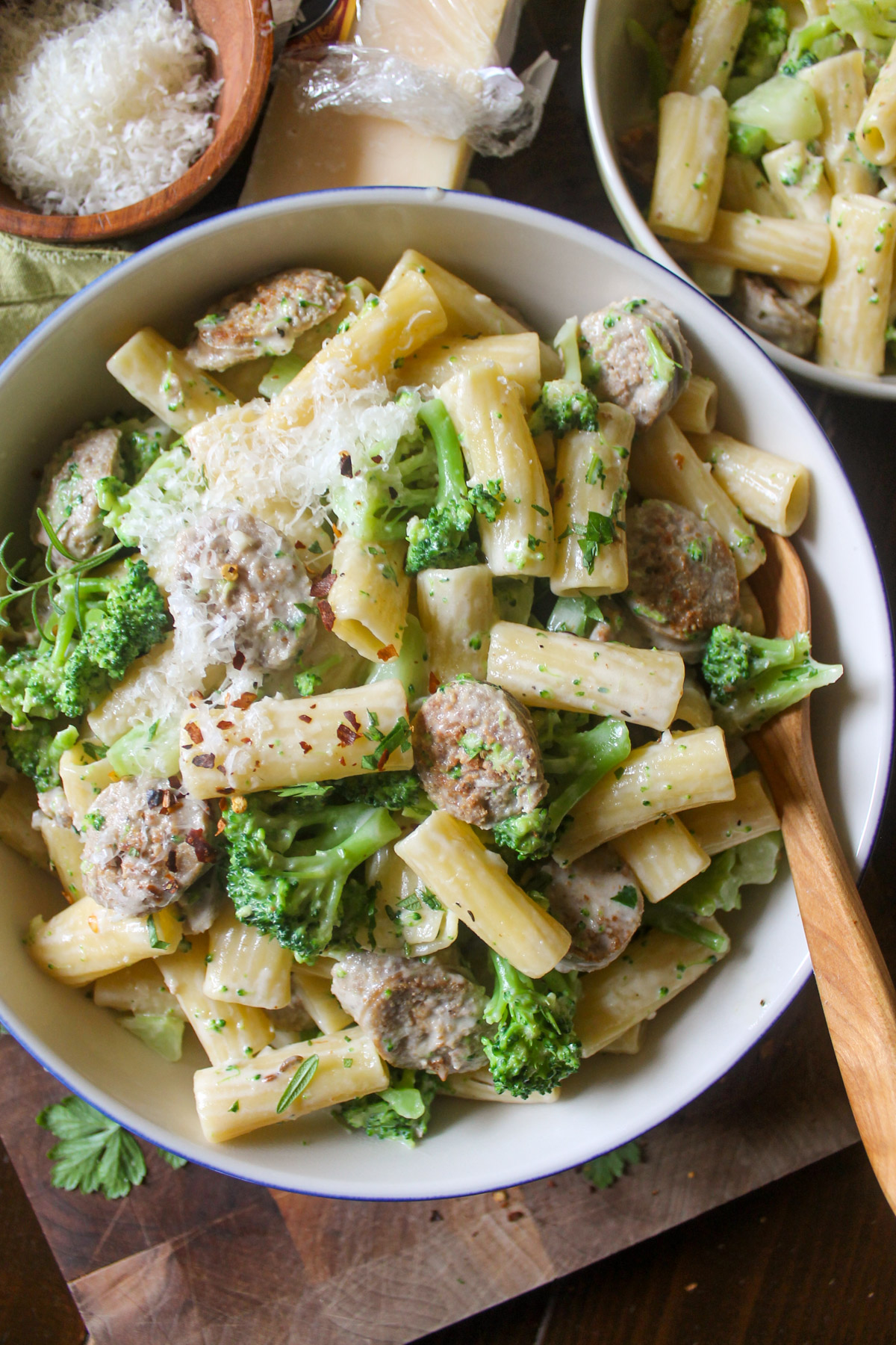 A bowl of sausage and broccoli pasta with cream sauce and Parmesan.