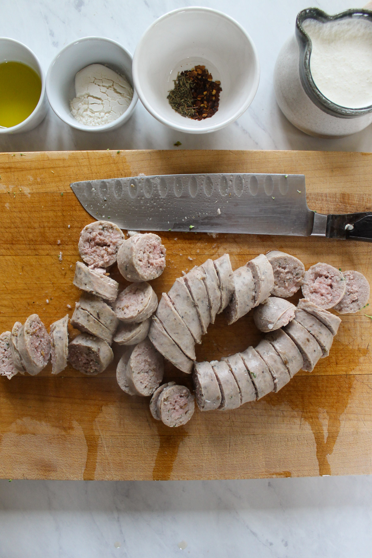 Sliced sausage links on a cutting board.