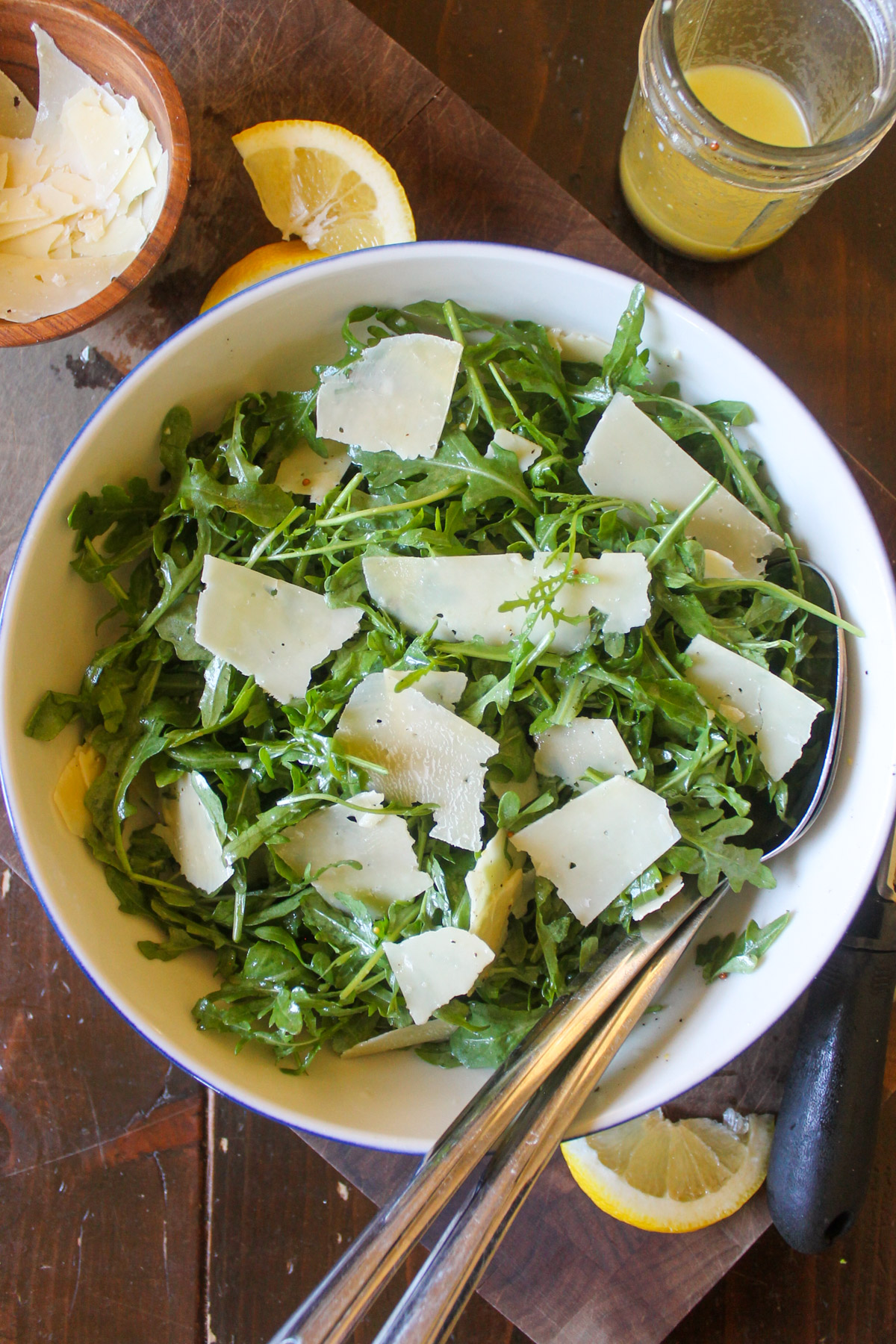 A bowl of arugula salad with Parmesan cheese and lemon vinagirette.