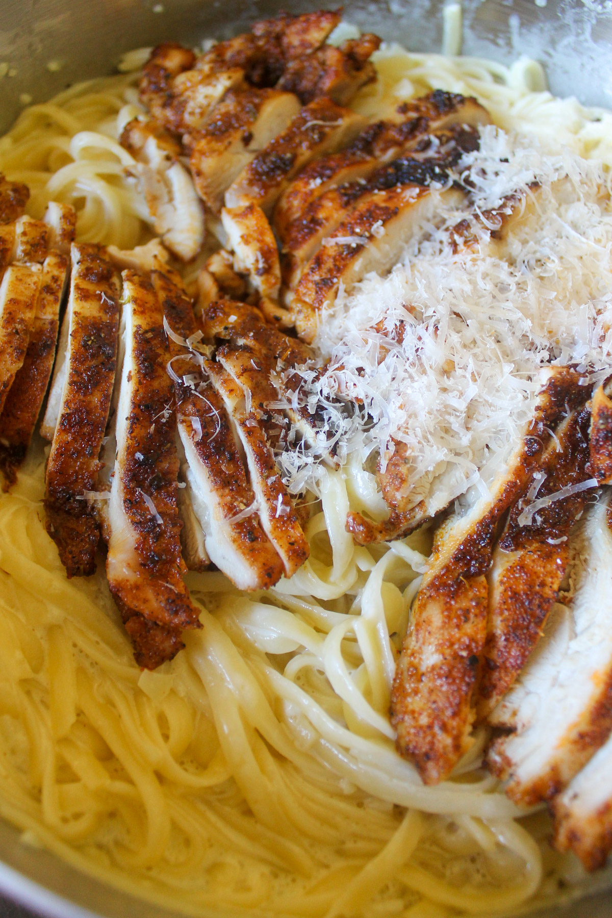 Blackened chicken sliced over creamy Alfredo pasta.