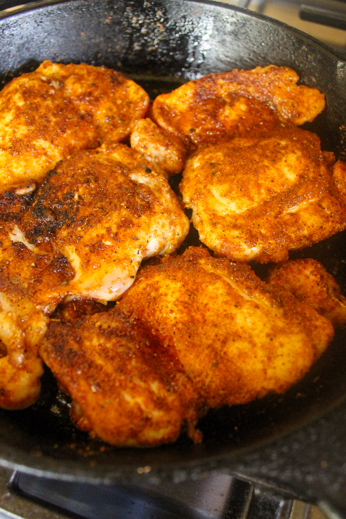 Cooking blackened chicken in a cast iron skillet.