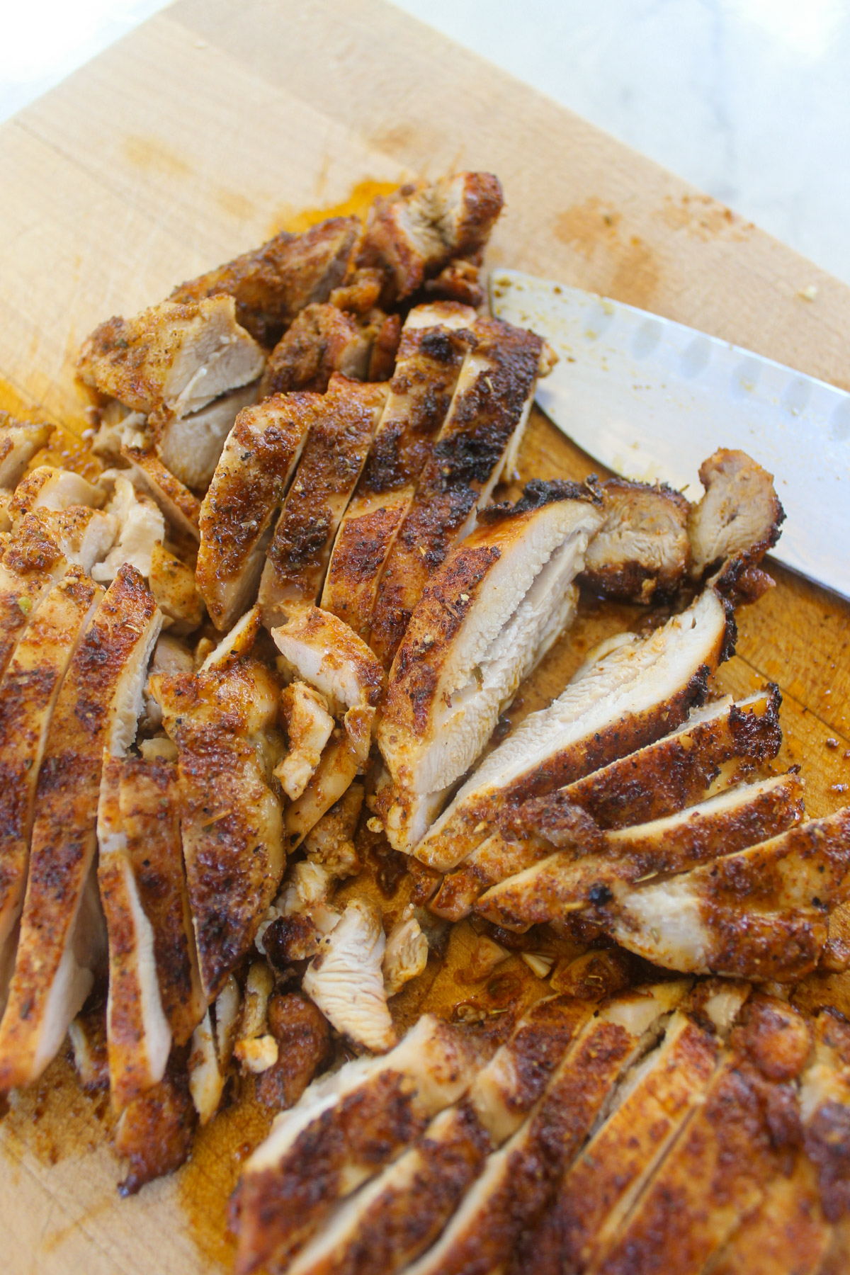 Blackened chicken sliced on a cutting board.