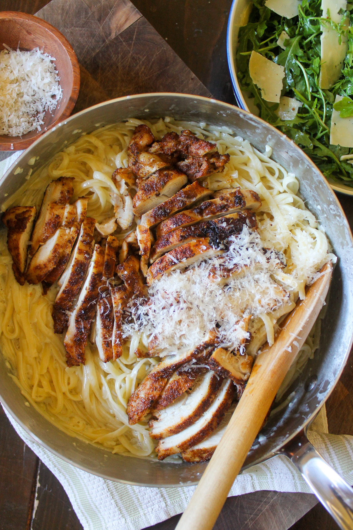 A skillet of Blackened Chicken Alfredo Pasta with Parmesan cheese.