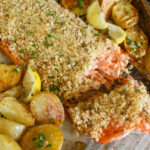 Baked salmon filet with almond topping and crispy potatoes.