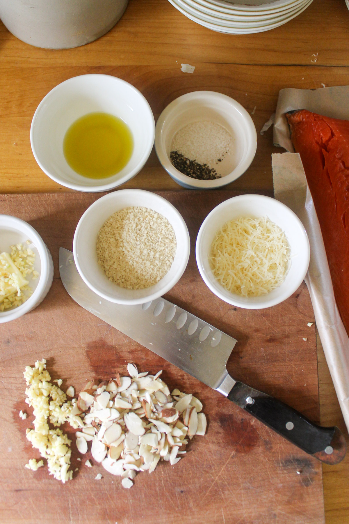 Chopping almonds and garlic on a cutting board.