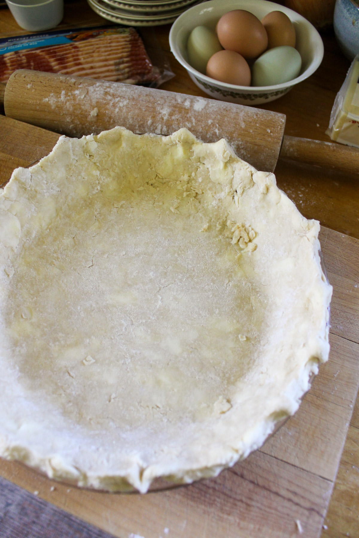An unbaked pie crust on a cutting board.