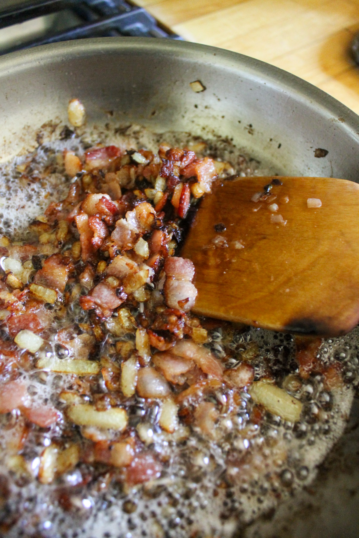 Cooked chopped bacon and onion in a skillet.
