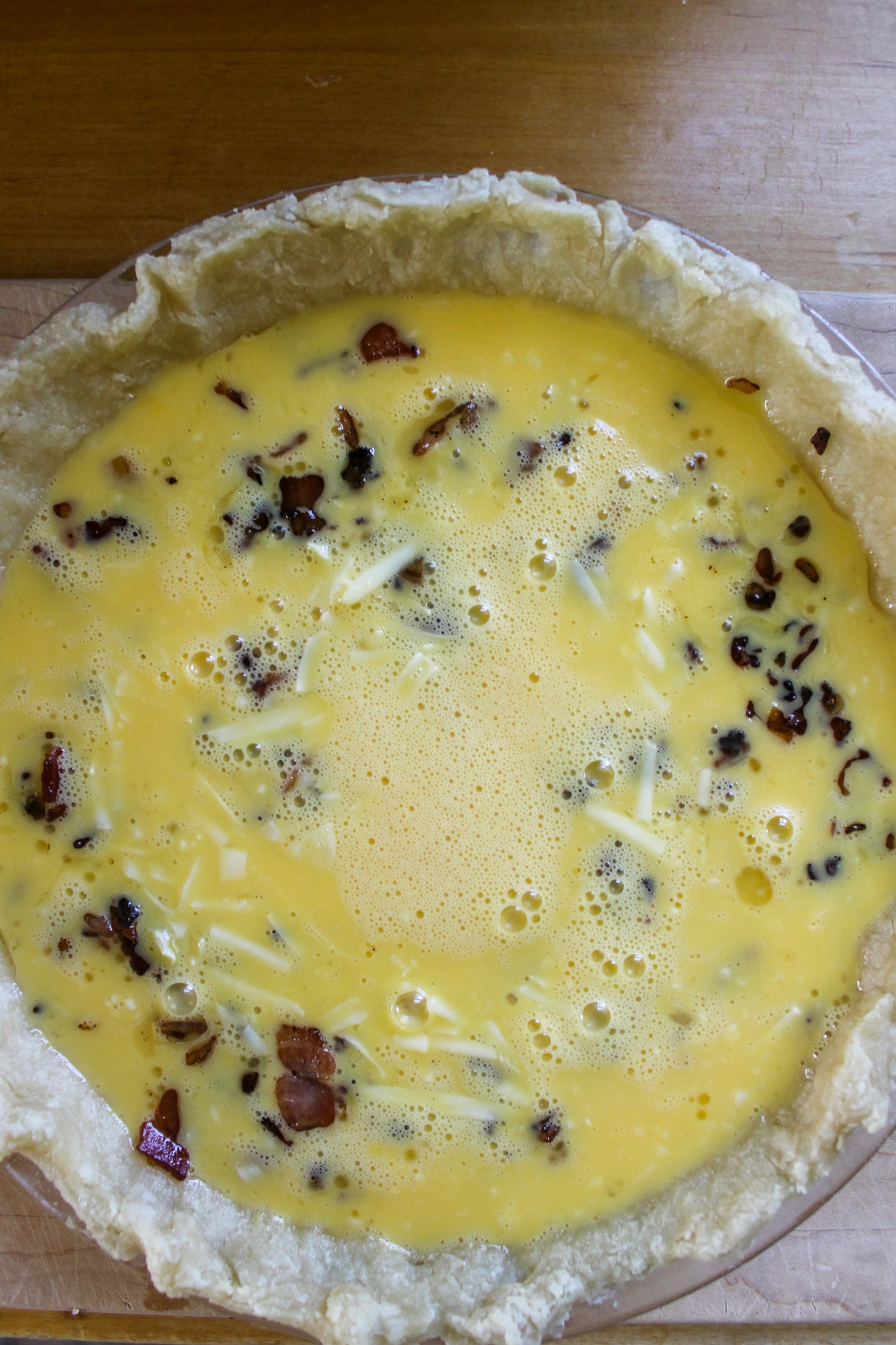 Eggs poured into a quiche, ready to bake.