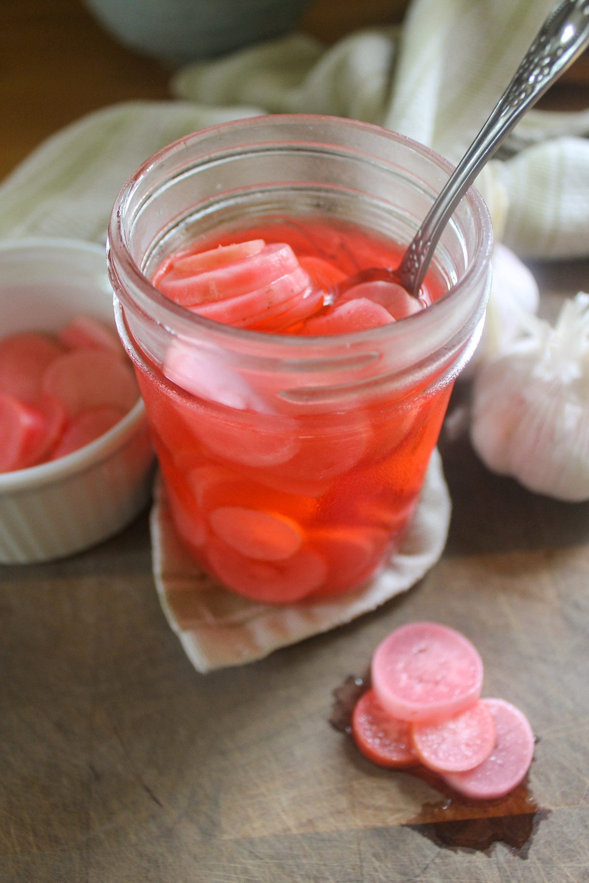 A pink jar of refrigerator pickled radishes.