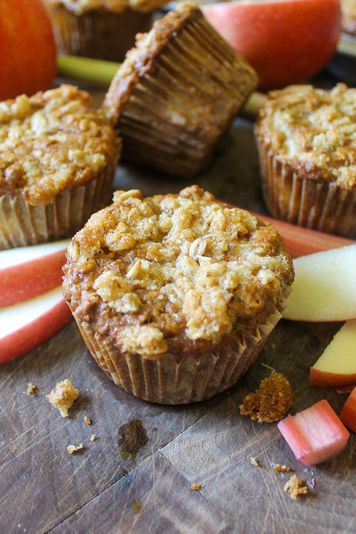 Apple Rhubarb muffins with sliced apples on a cutting board.