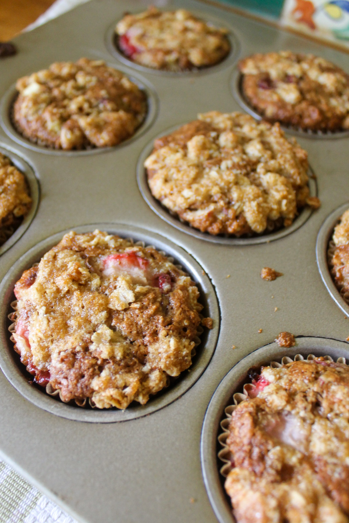 Baked Strawberry Rhubarb Muffins in a muffin tin.