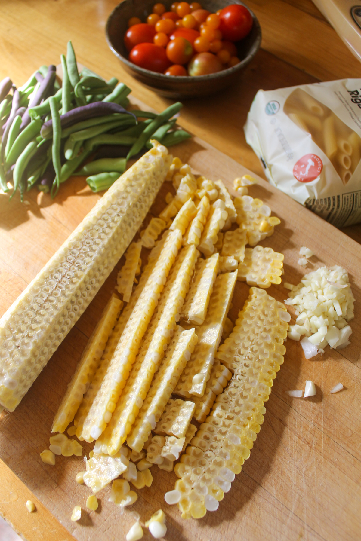 Slicing corn kernels off the cob.
