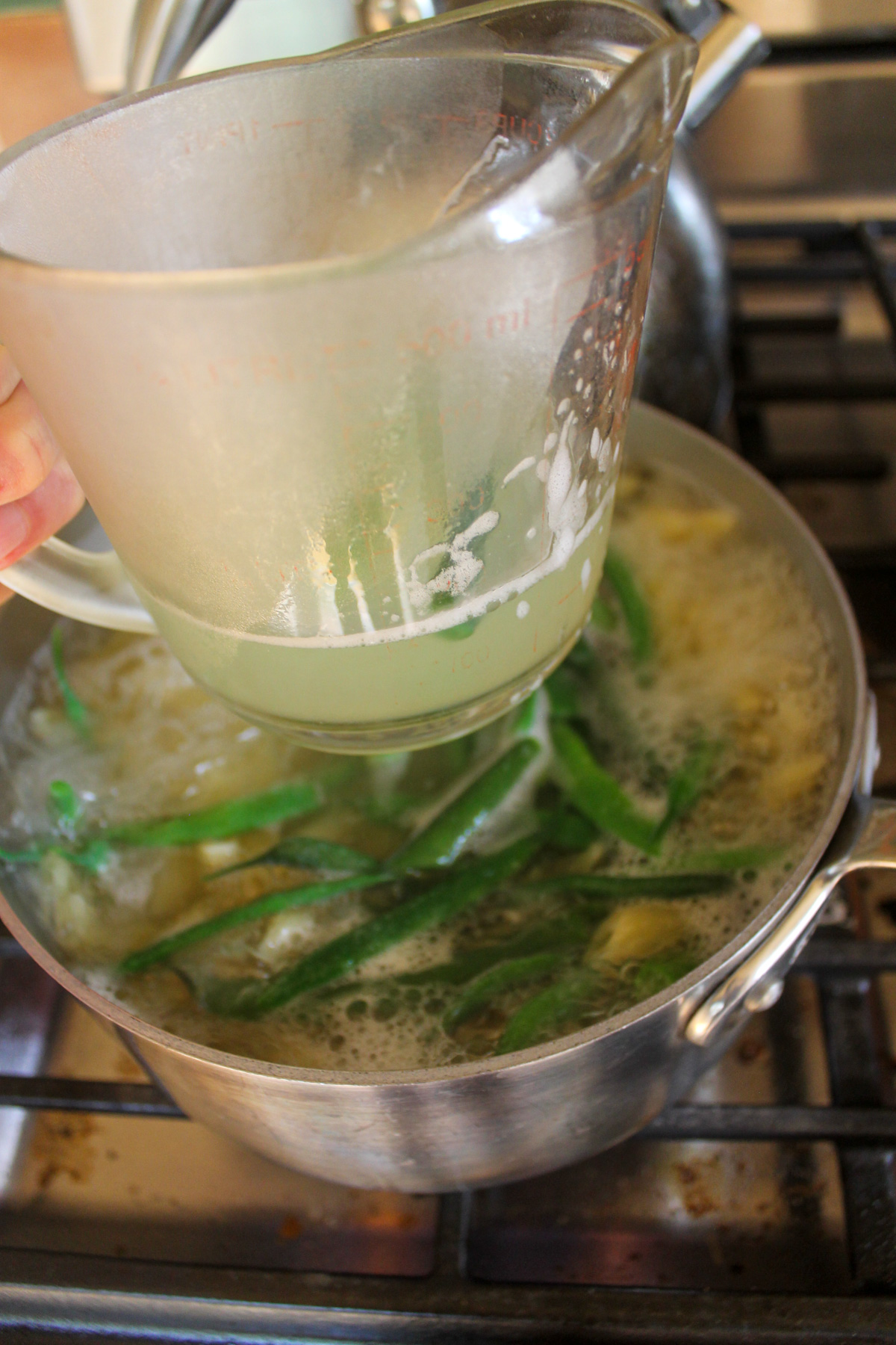 Scooping out and saving the starchy pasta cooking water.