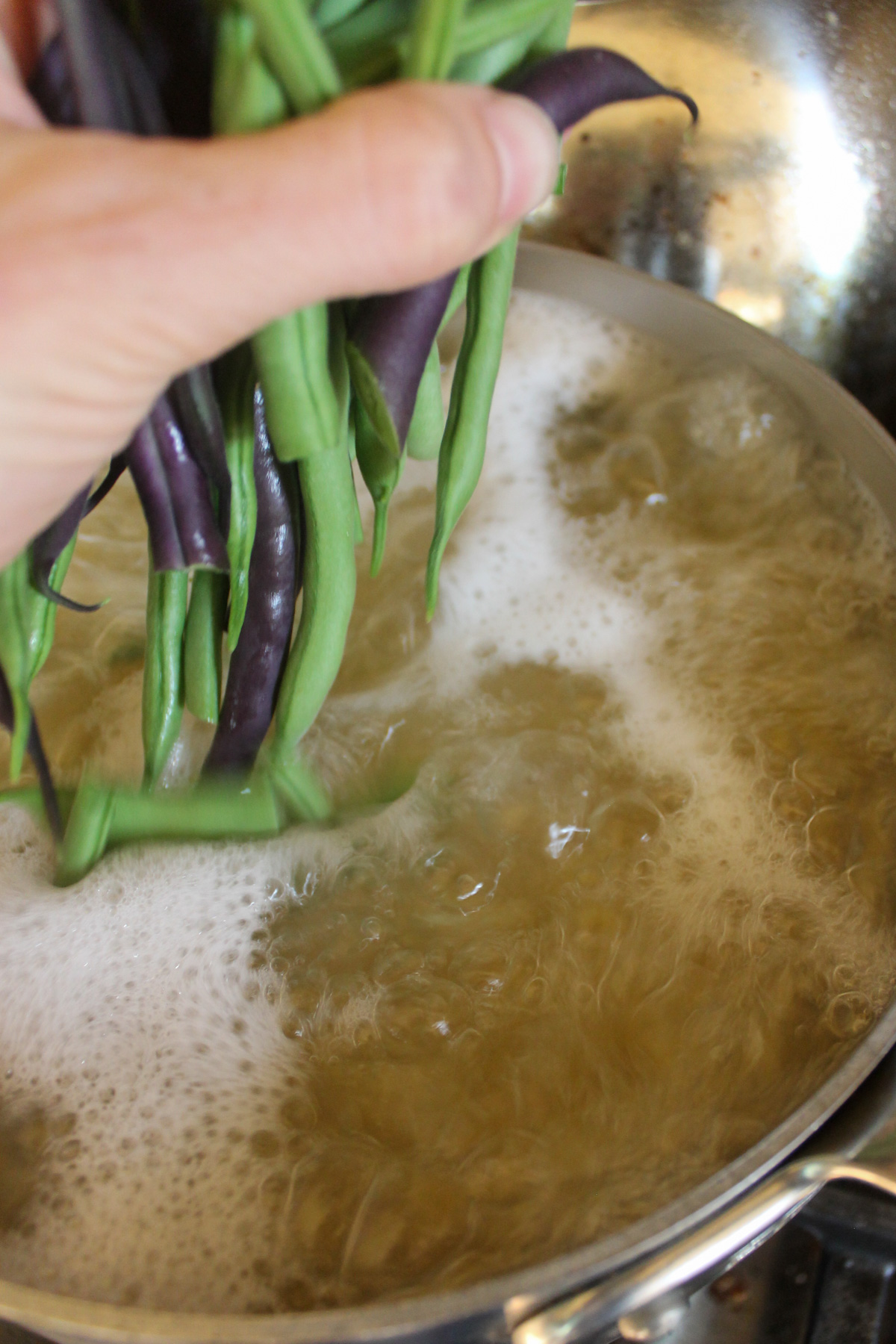 Adding fresh green beans to boil with the pasta.