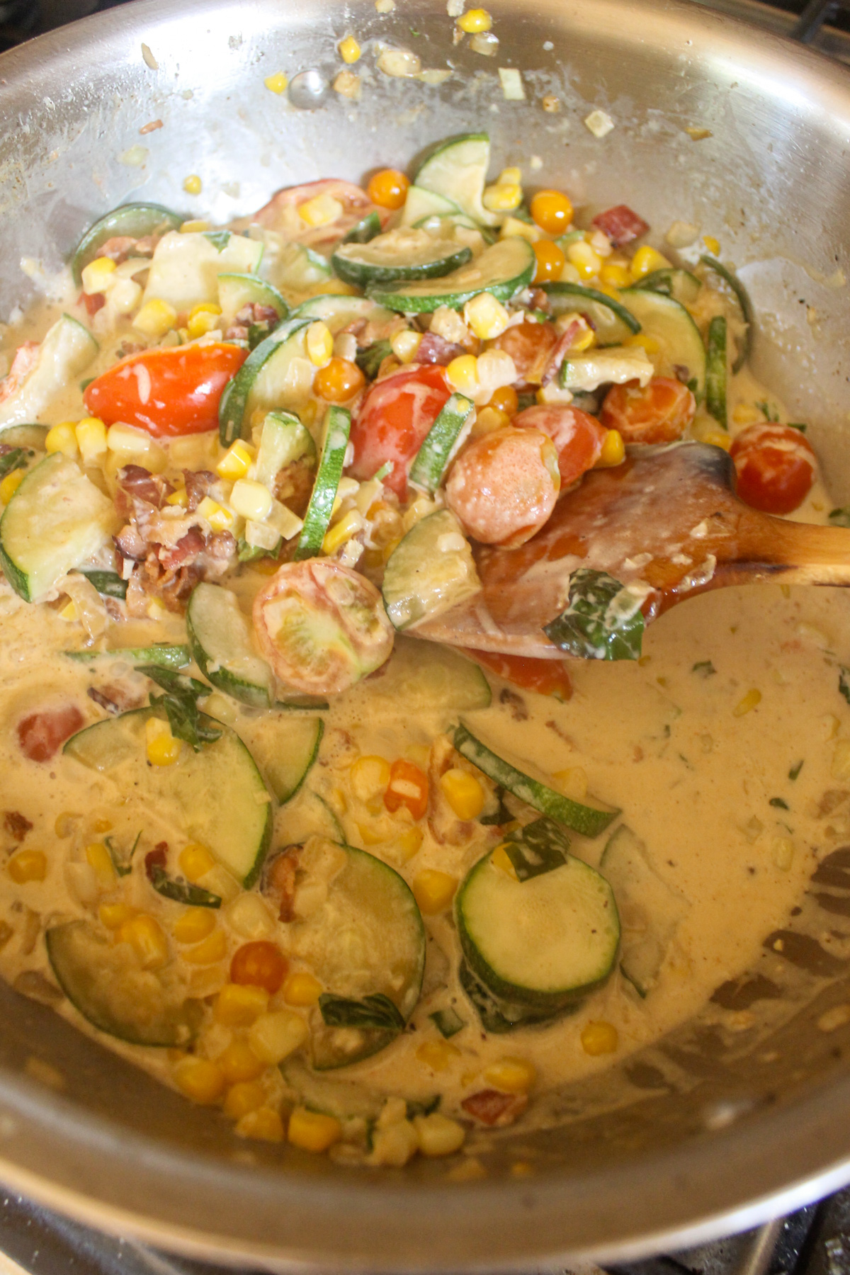 Garden vegetable cream sauce in a skillet.