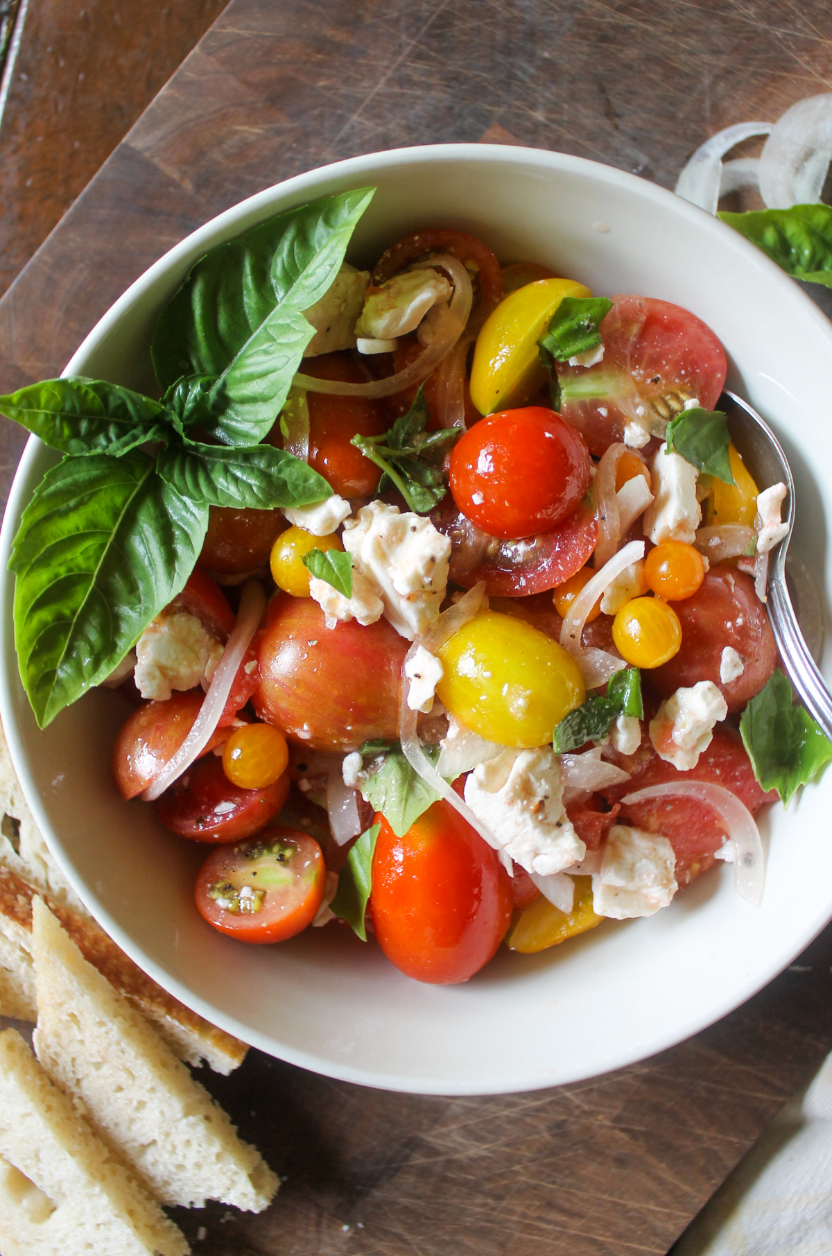 A bowl of Tomato Onion Salad with basil.
