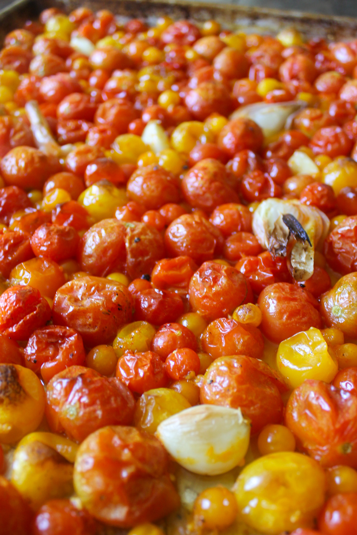 Cherry tomatoes roasted on a sheet pan.