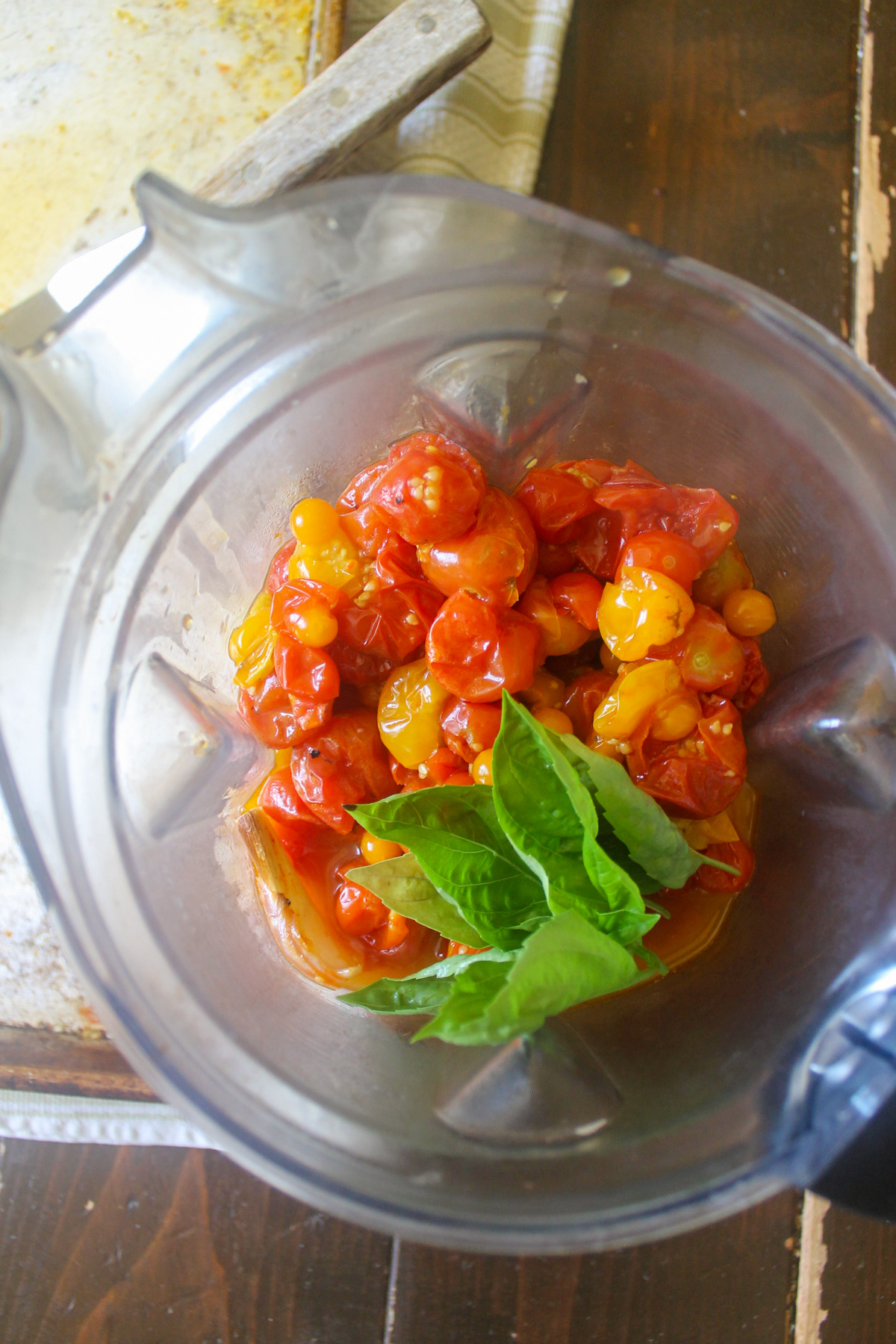 Roasted cherry tomatoes in a blender with basil.