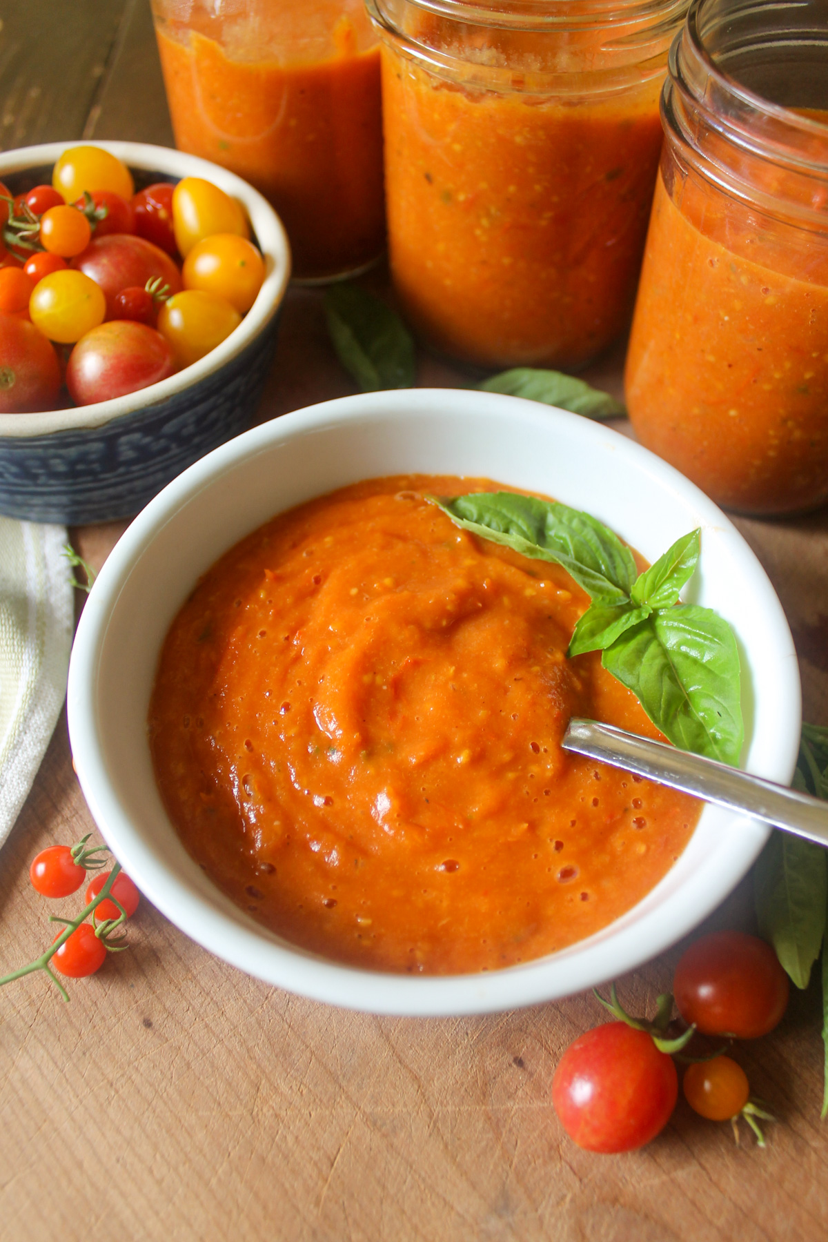 A bowl of tomato sauce with 3 jars for the freezer.