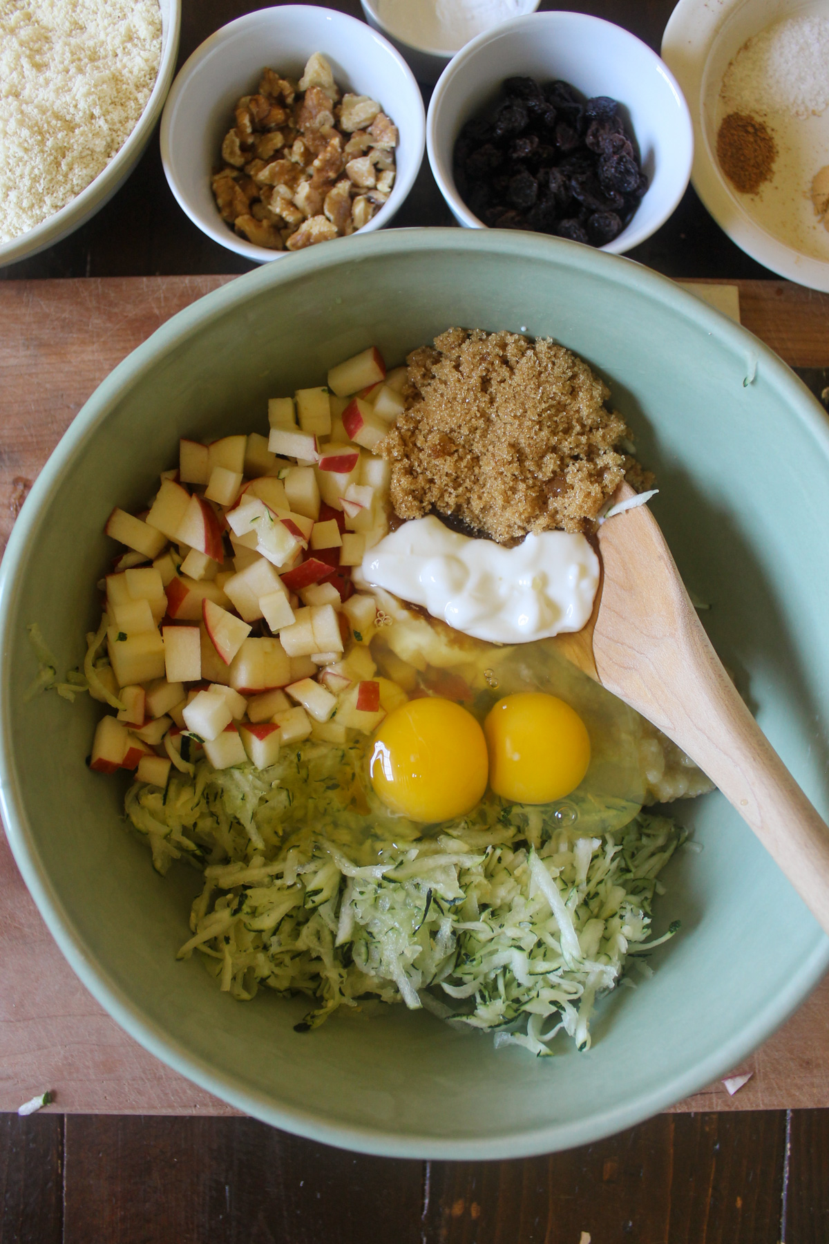 Zucchini, apple, brown sugar, eggs, applesauce and yogurt in a mixing bowl.